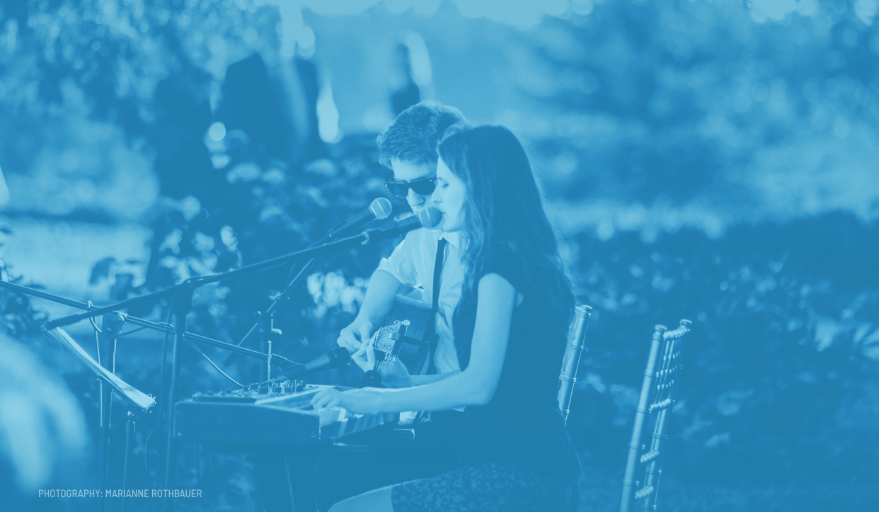 Guitar and keyboard duo performing at an outdoor wedding ceremony